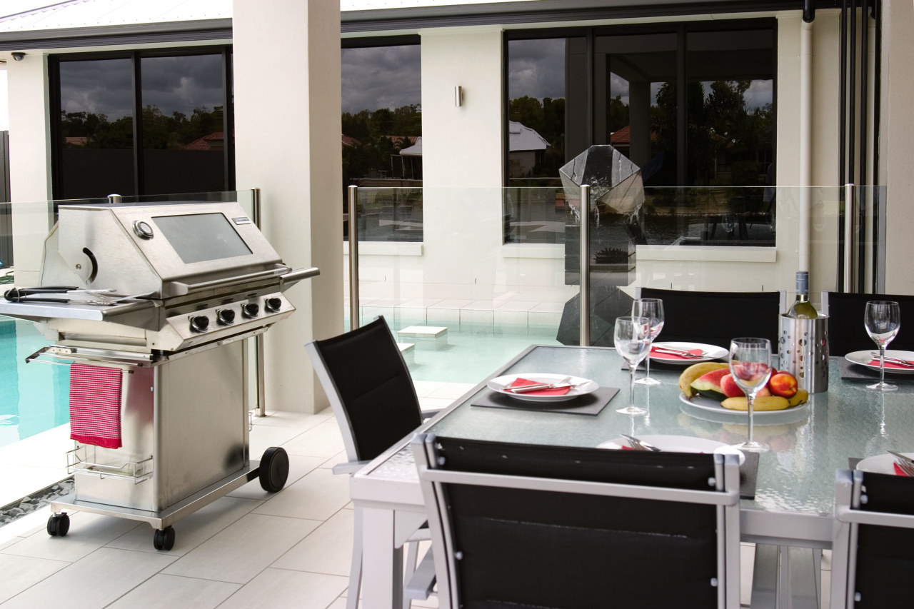 Outdoor patio and pool area with dining table, kitchen, window, white, black, gray