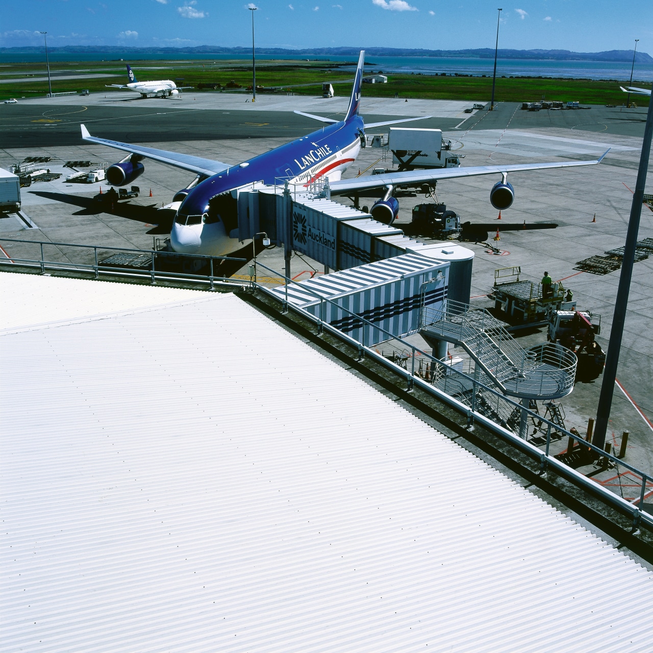 View of roof of airport building with walkway air travel, airplane, airport, airport apron, aviation, marina, roof, sky, water, white