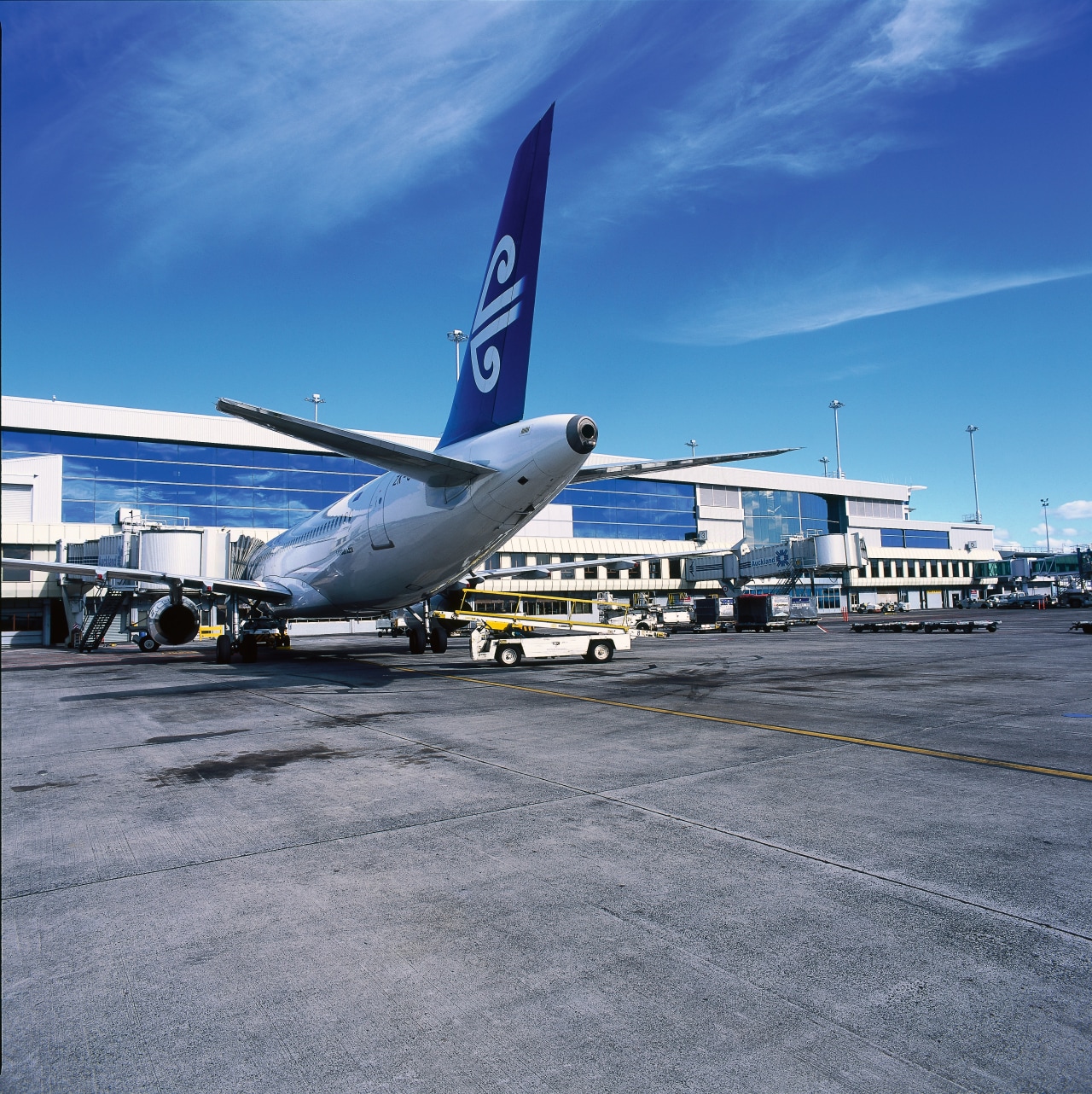 View of new passenger building with plane in aerospace engineering, air travel, airbus, airbus a320 family, airbus a330, aircraft, airline, airliner, airplane, airport, airport apron, airport terminal, aviation, boeing, boeing 737, boeing 767, boeing 777, daytime, flap, jet aircraft, narrow body aircraft, sky, transport, travel, wide body aircraft, blue, gray