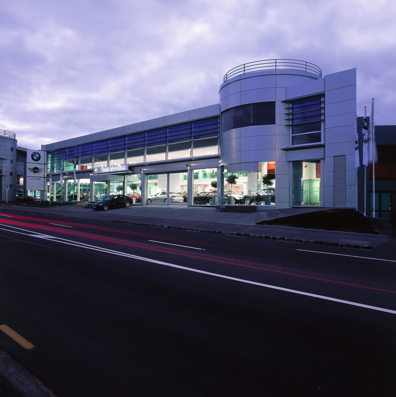 Exterior view of BMW showroom, with grey cladding. architecture, building, car, commercial building, corporate headquarters, facade, infrastructure, luxury vehicle, metropolis, metropolitan area, mixed use, residential area, sky, black, purple