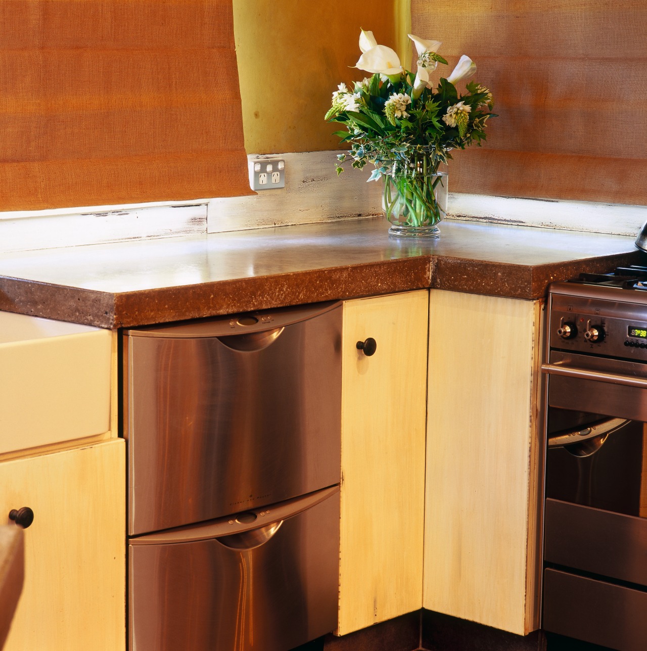 View of kitchen cabinetry with double dish drawer cabinetry, chest of drawers, countertop, drawer, furniture, hardwood, interior design, kitchen, room, table, wood, wood stain, brown, orange