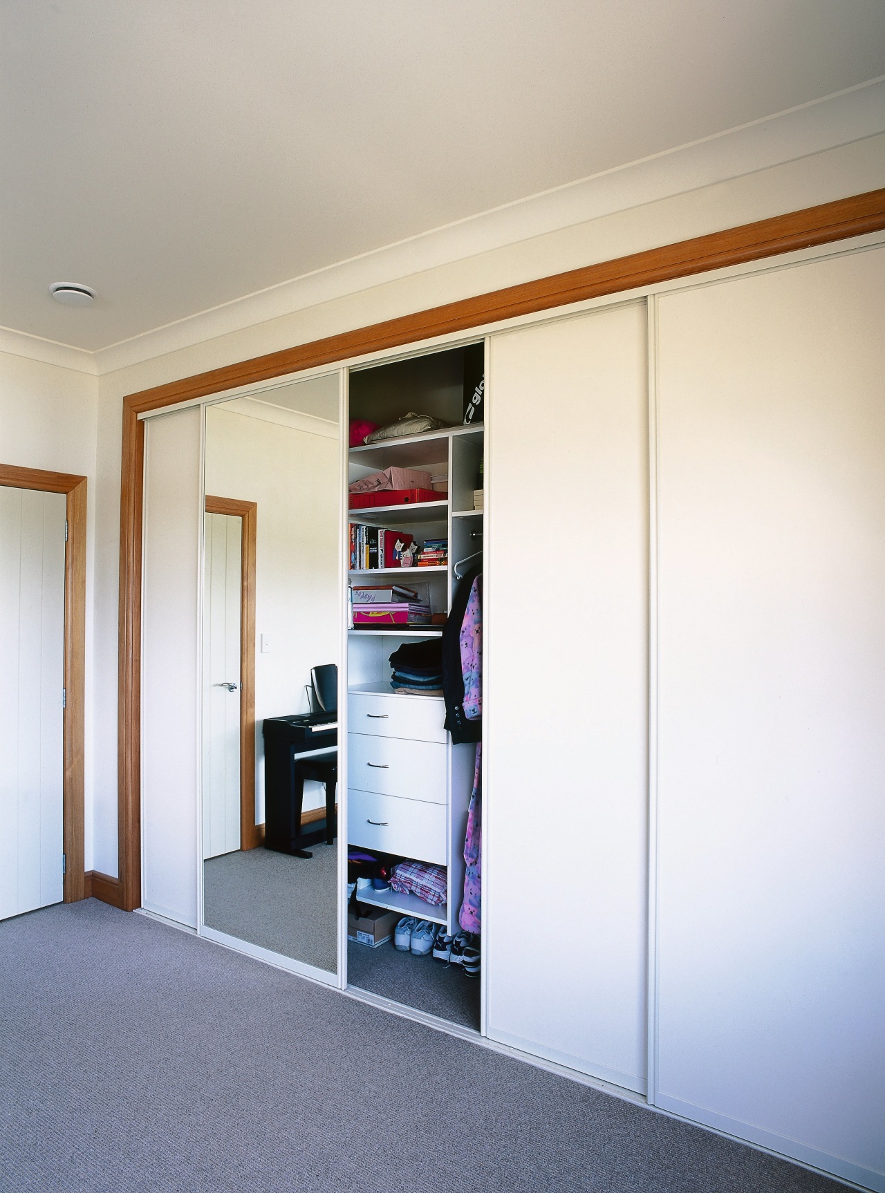 View of wardrobe storage system with sliding doors. door, furniture, interior design, room, sliding door, wardrobe, wood, white