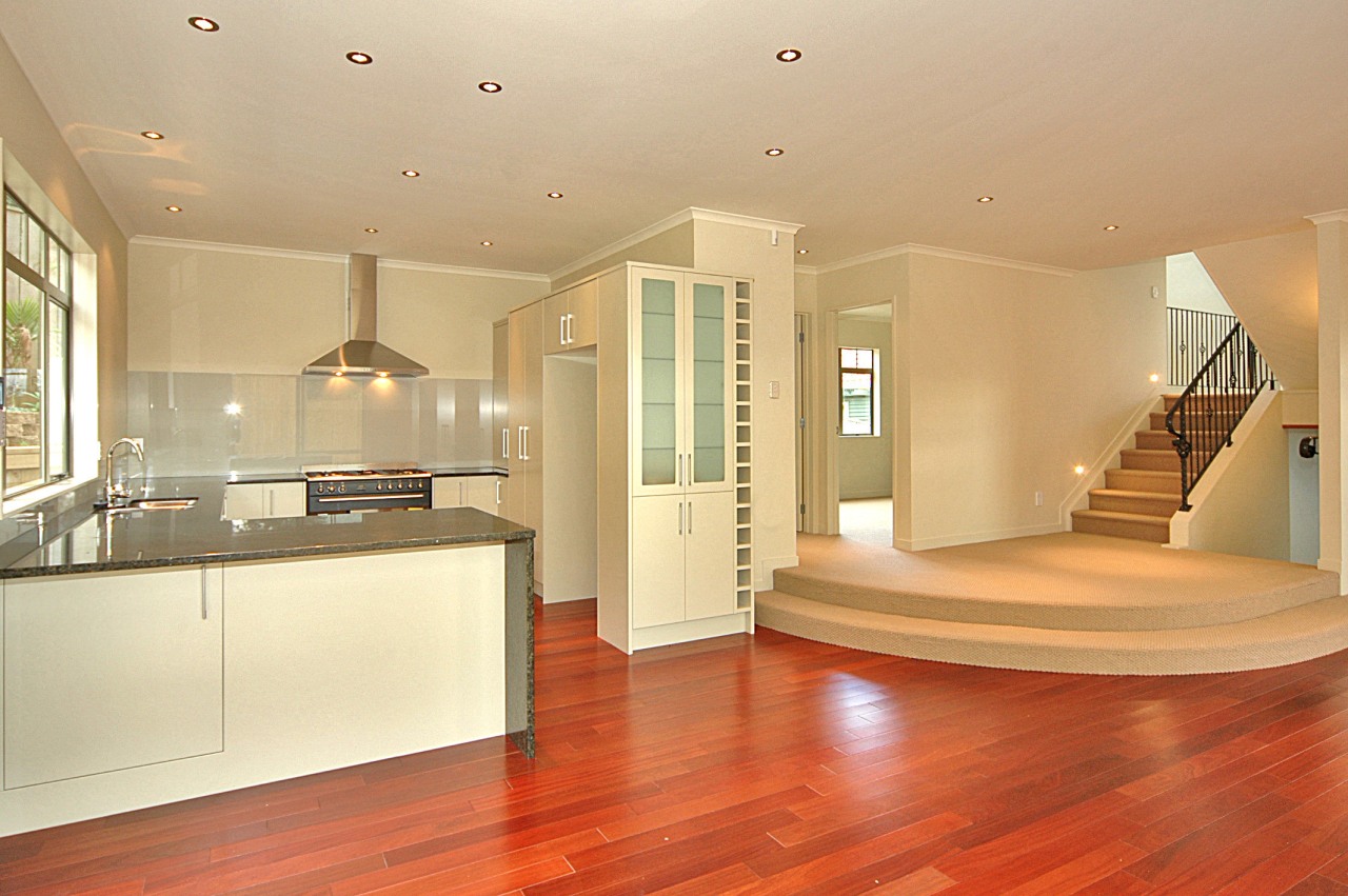 Open plan kitchen and stairway area with red architecture, ceiling, estate, floor, flooring, hardwood, home, interior design, kitchen, laminate flooring, living room, property, real estate, room, wood, wood flooring, orange