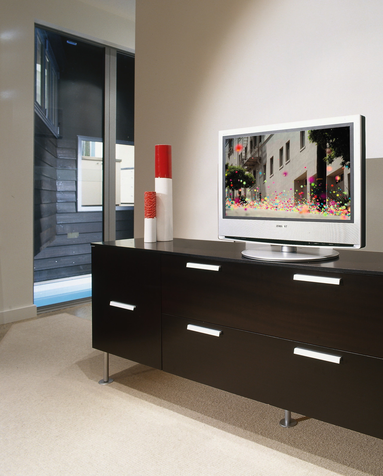 Brown drawer cabinet with LCD tv on top. chest of drawers, display case, display device, flat panel display, furniture, interior design, living room, product design, shelf, shelving, sideboard, table, white, black