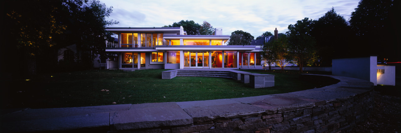 view of this architecturally designed house featuring architecture, cottage, estate, evening, facade, home, house, landscape lighting, light, lighting, mansion, night, property, real estate, residential area, sky, black