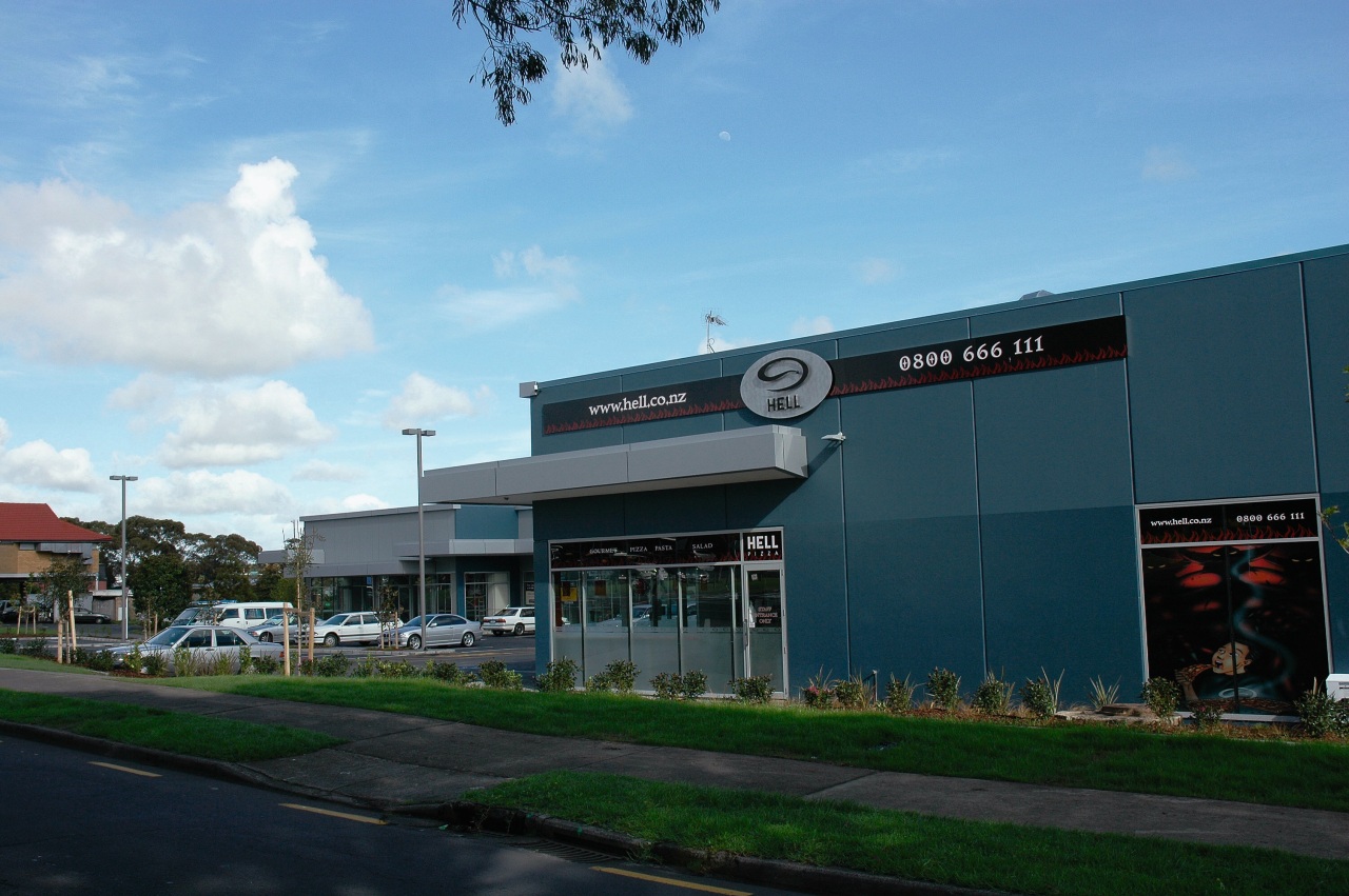 A view of a convenience centre developed by building, car, corporate headquarters, real estate, sky, teal, black