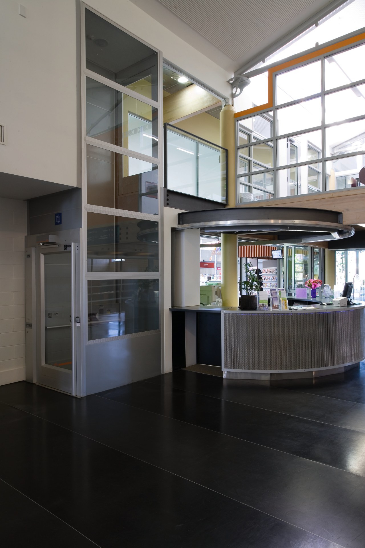 Disability lift in office reception area. architecture, floor, glass, interior design, lobby, black, gray