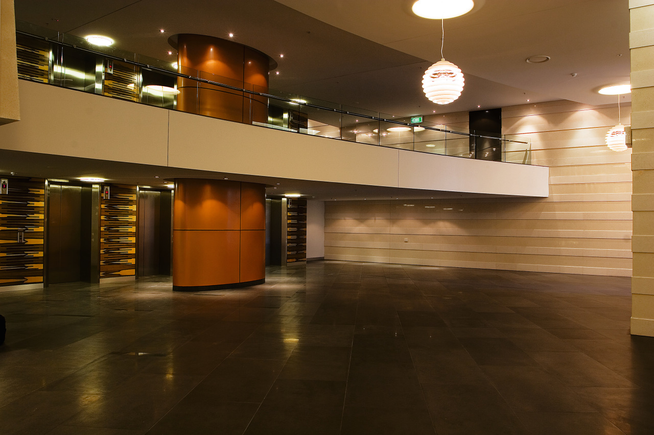 Lobby area of apartment building featuring limestone tiles architecture, ceiling, floor, flooring, hardwood, interior design, lighting, lobby, wood, brown