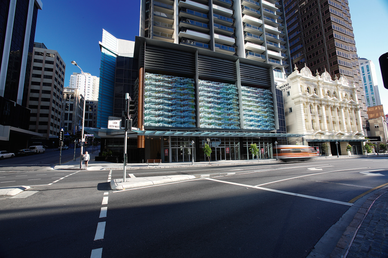 Road frontage of apartment building showing artwork facade. architecture, building, car, city, cityscape, commercial building, condominium, daytime, downtown, facade, infrastructure, landmark, lane, luxury vehicle, metropolis, metropolitan area, mixed use, neighbourhood, road, sky, skyscraper, street, tower block, urban area, window, blue
