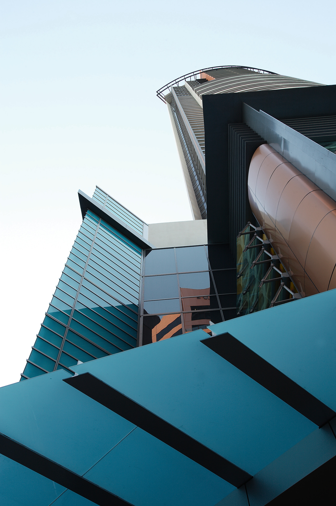 View looking up at apartment exterior with contemporary angle, architecture, building, daylighting, daytime, facade, glass, line, metropolitan area, roof, sky, skyscraper, structure, urban area, white, teal