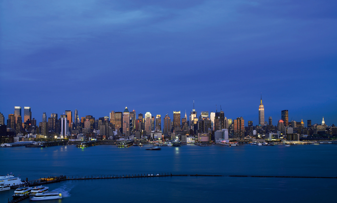 view of the manhattan CBd skyline accross the city, cityscape, daytime, downtown, dusk, evening, horizon, landmark, metropolis, metropolitan area, night, reflection, sea, sky, skyline, skyscraper, tower block, urban area, water, blue