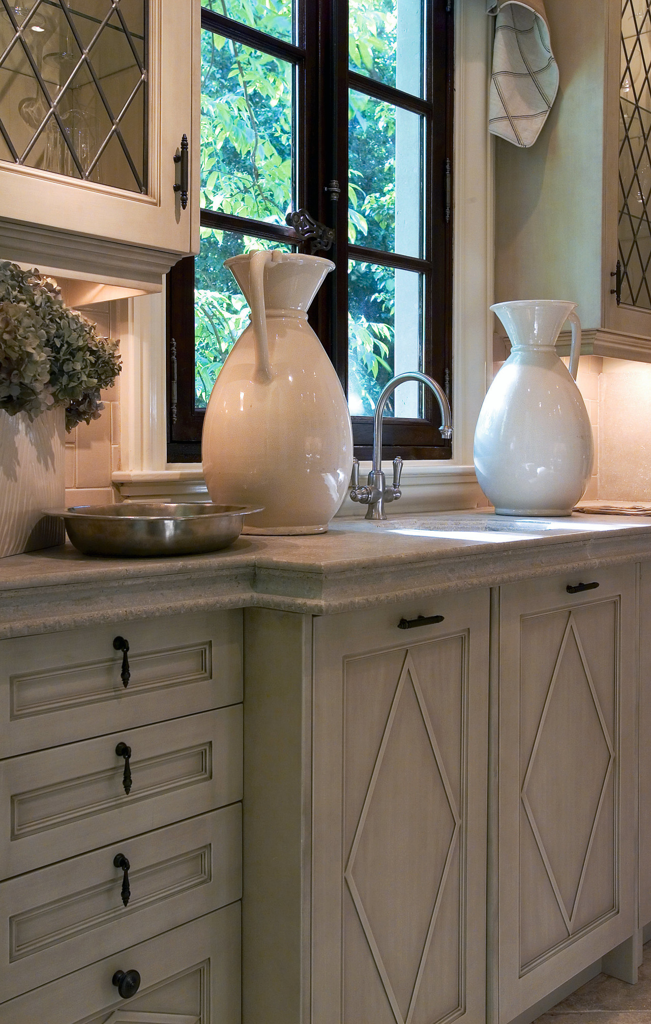 A view of a kitchen by Design Galleria bathroom accessory, cabinetry, chest of drawers, countertop, drawer, furniture, home, interior design, kitchen, room, sink, table, wood stain, brown, gray