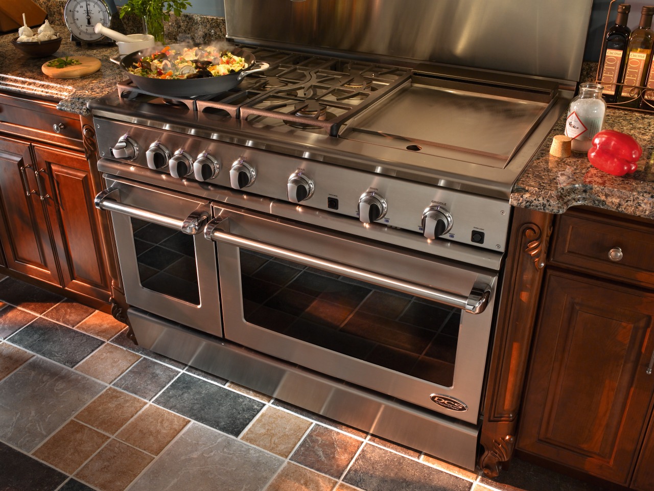 view of the kitchen featuring a DCS stainless countertop, flooring, gas stove, home appliance, kitchen, kitchen appliance, kitchen stove, major appliance, oven, brown, black