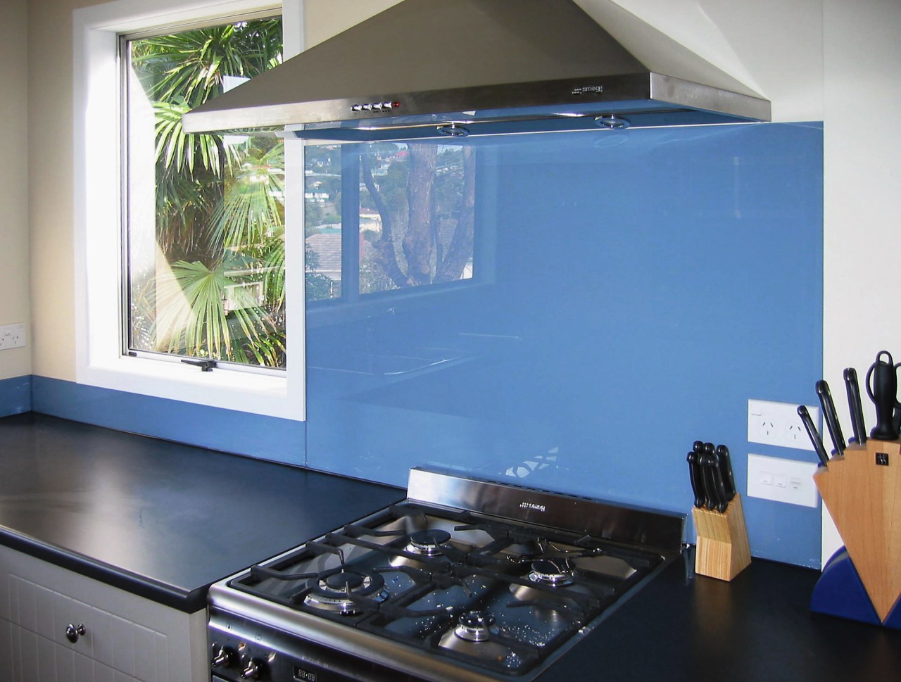 A view of a glass splashback by Glass countertop, glass, home appliance, interior design, kitchen, room, window, teal