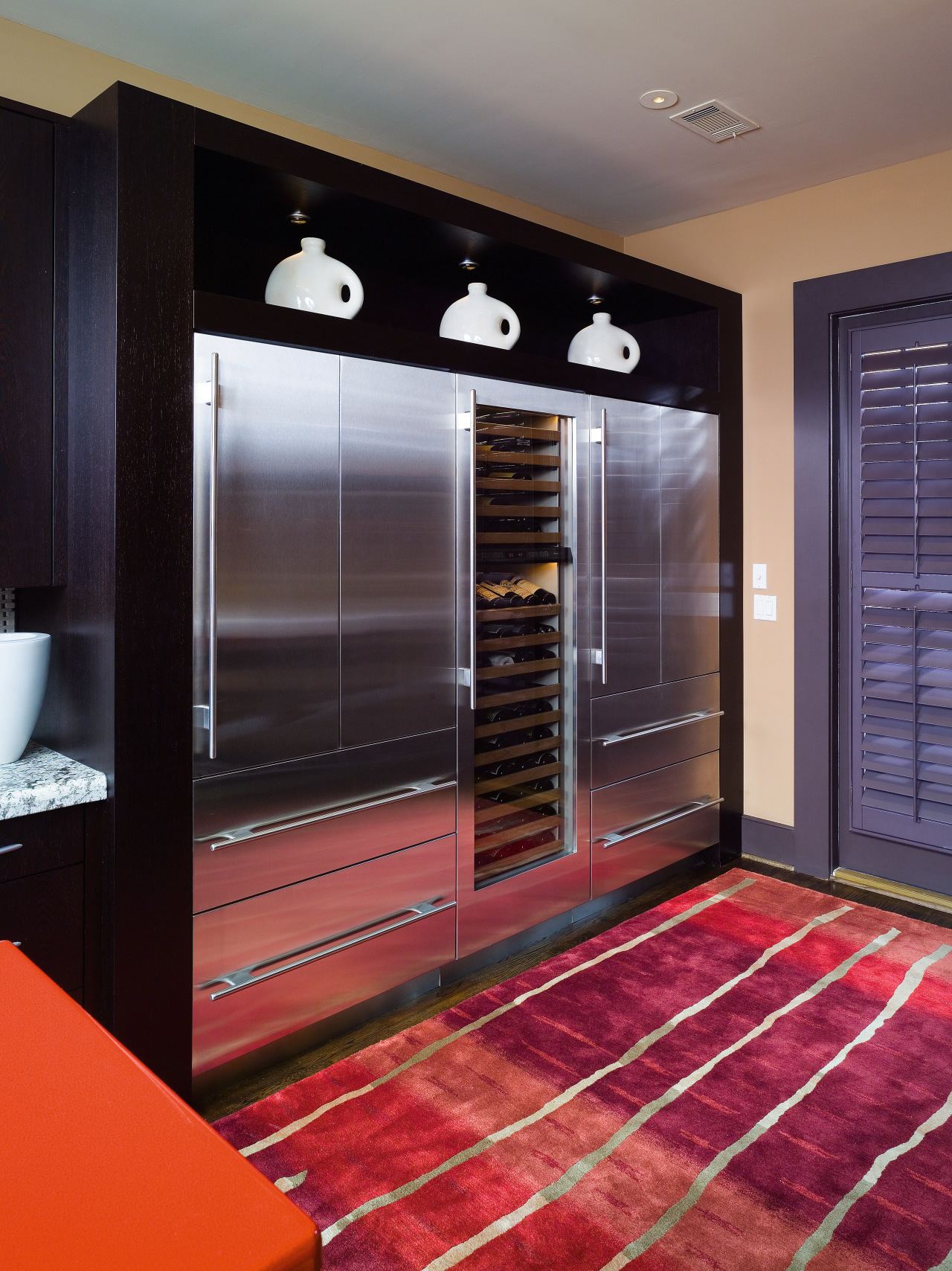 A view of this kitchen featuring black cabinetry, cabinetry, closet, floor, flooring, furniture, interior design, room, wardrobe, black, red