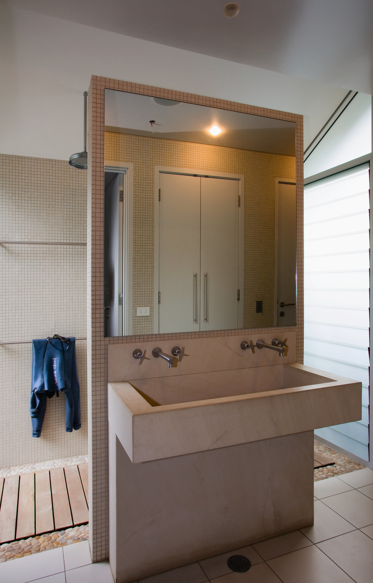 A view of the bathrom featuring tiled walls/flooring, bathroom, bathroom accessory, bathroom cabinet, cabinetry, interior design, room, sink, gray, brown