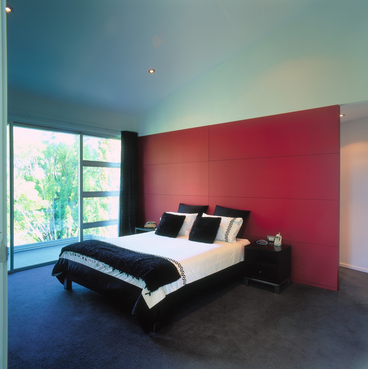 A view of the master bedroom, red feature architecture, bed, bed frame, bedroom, ceiling, floor, furniture, home, interior design, lighting, mattress, property, real estate, room, wall, window