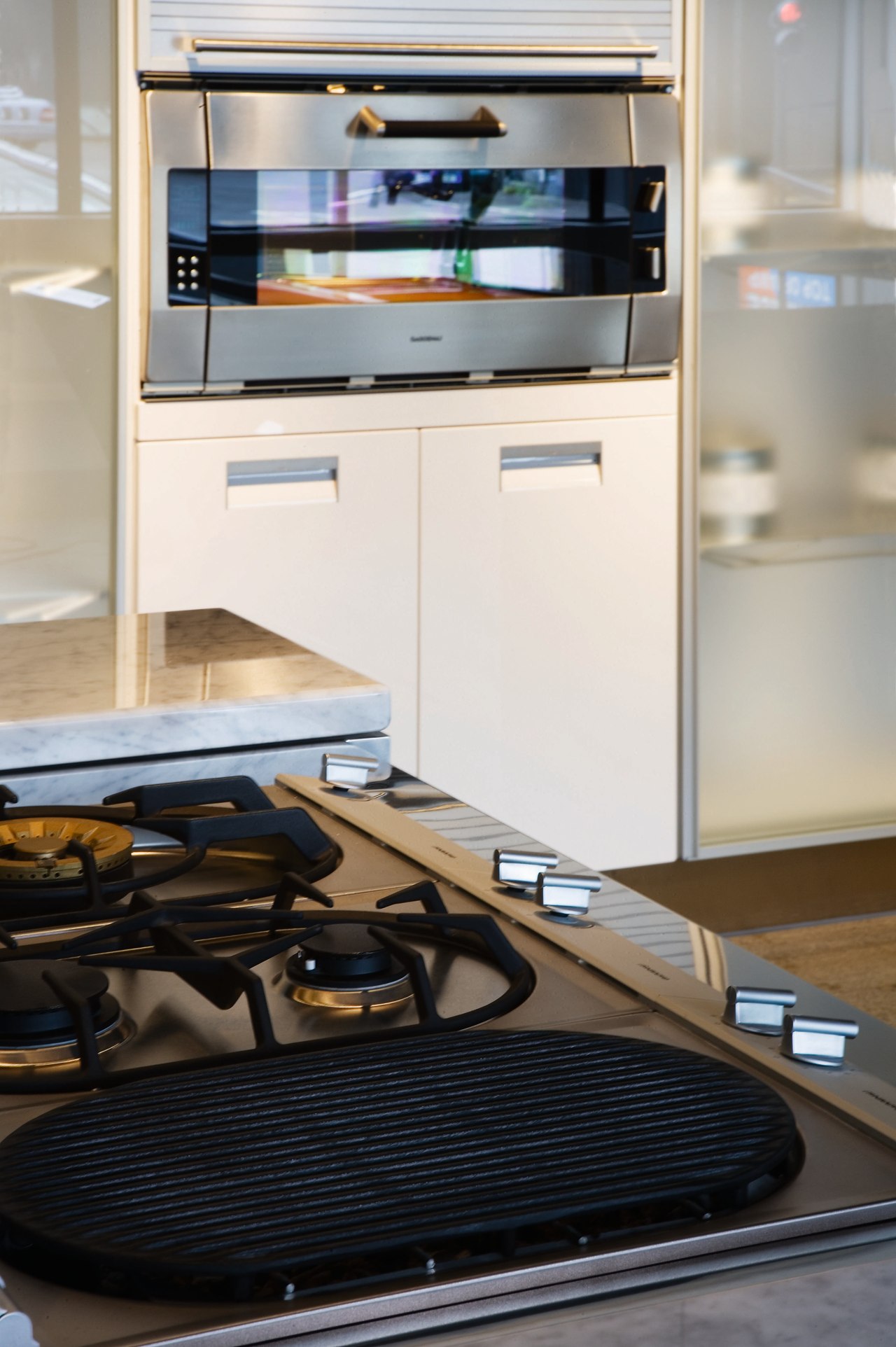A close up view of a cooktop. countertop, floor, flooring, furniture, home appliance, kitchen, product design, white, black