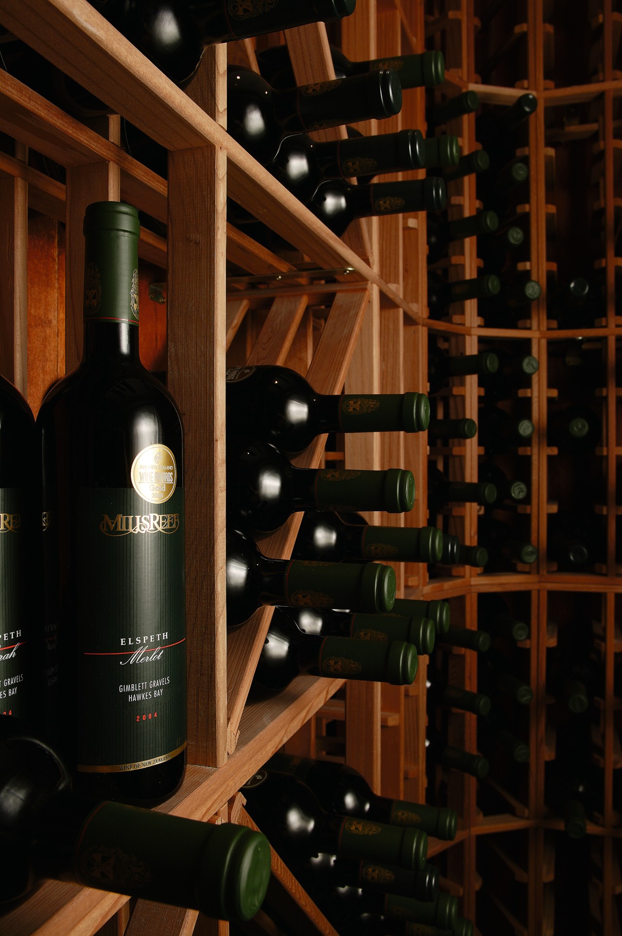 A view of a wine cellar by Baywick's alcoholic beverage, bottle, distilled beverage, drink, glass bottle, liquor store, wine, wine cellar, winery, wood, black, brown