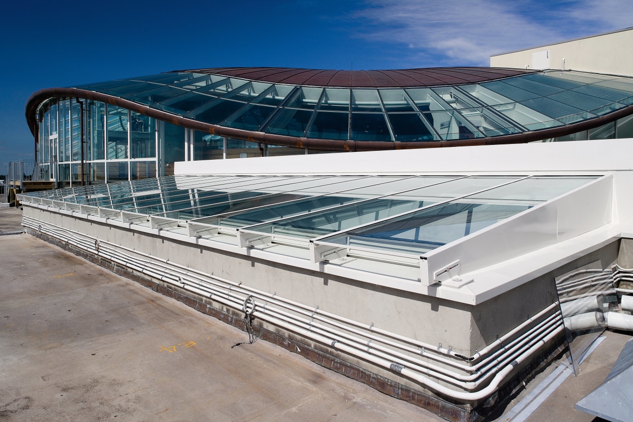 A vie wof some glass windows from Woods architecture, building, corporate headquarters, daylighting, roof, structure, gray