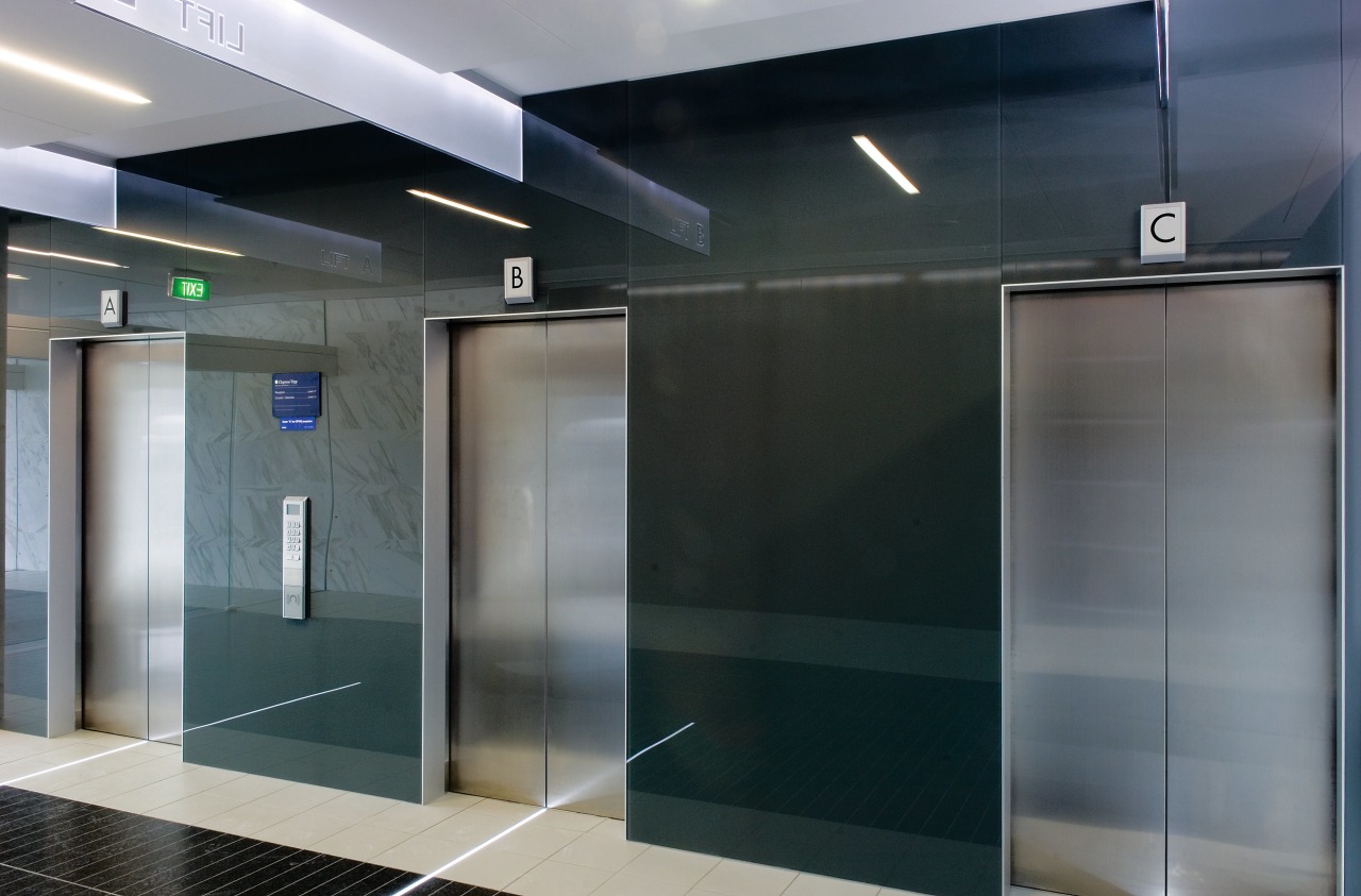 A view of the elevator lobby feauting glass glass, interior design, gray, black