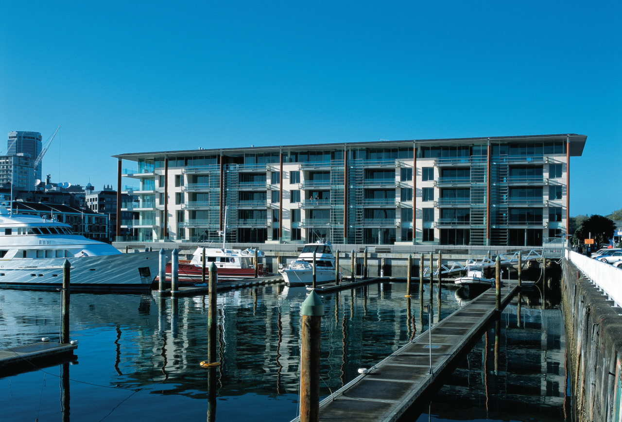 An exterior view of the lighter quay apartment architecture, building, city, condominium, corporate headquarters, dock, harbor, marina, mixed use, real estate, reflection, sky, water, water transportation, waterway, teal