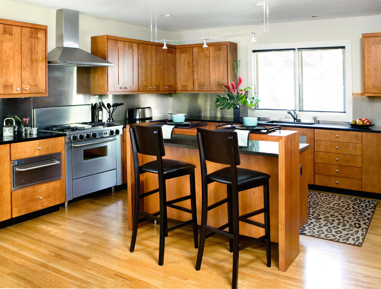 A view of this kitchen featuring stained timber cabinetry, countertop, cuisine classique, floor, flooring, hardwood, interior design, kitchen, laminate flooring, room, wood, wood flooring, white, orange