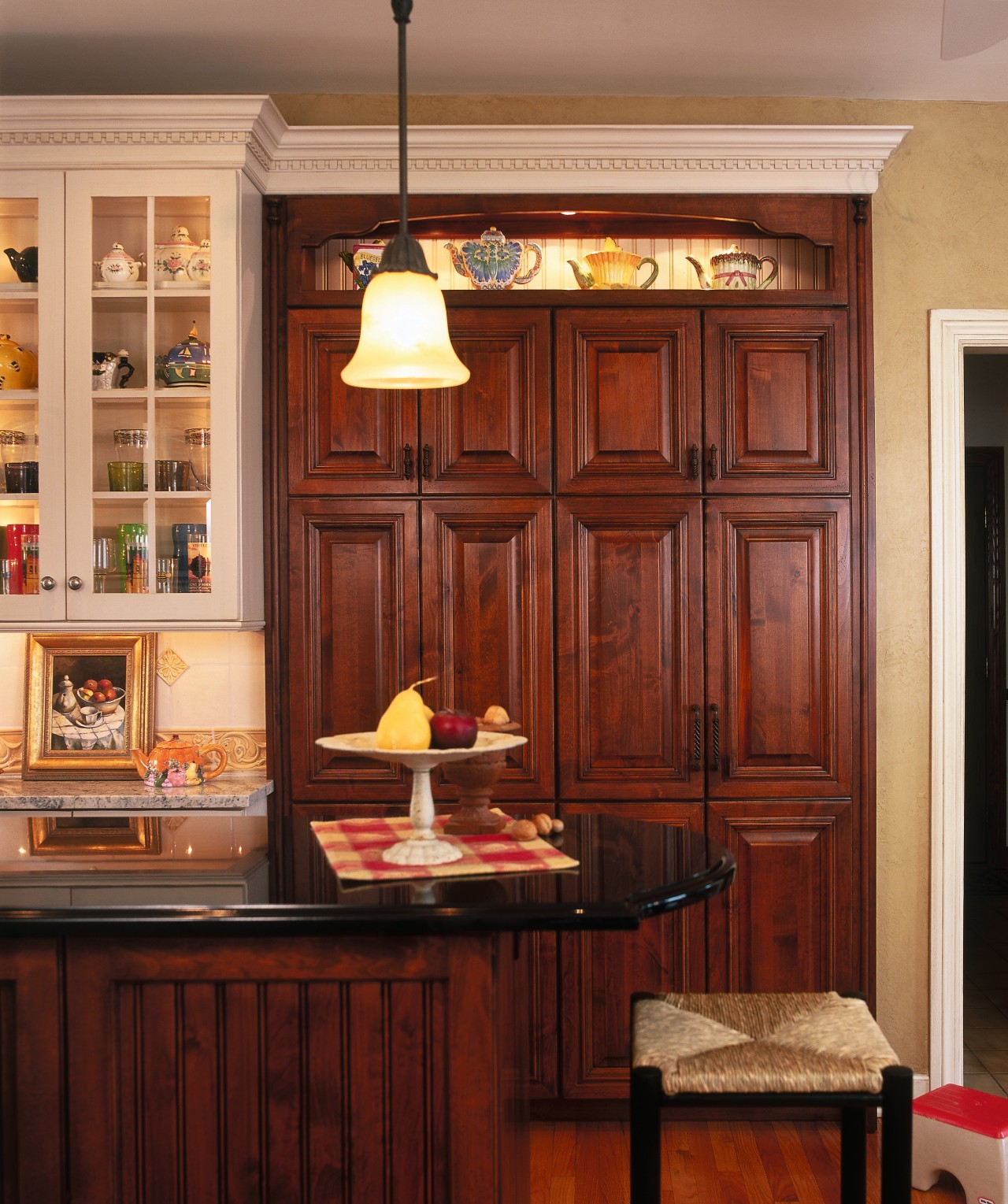 View of this traditional designed kitchen featuring granite cabinetry, countertop, cuisine classique, dining room, furniture, interior design, kitchen, room, shelving, table, wall, window, red