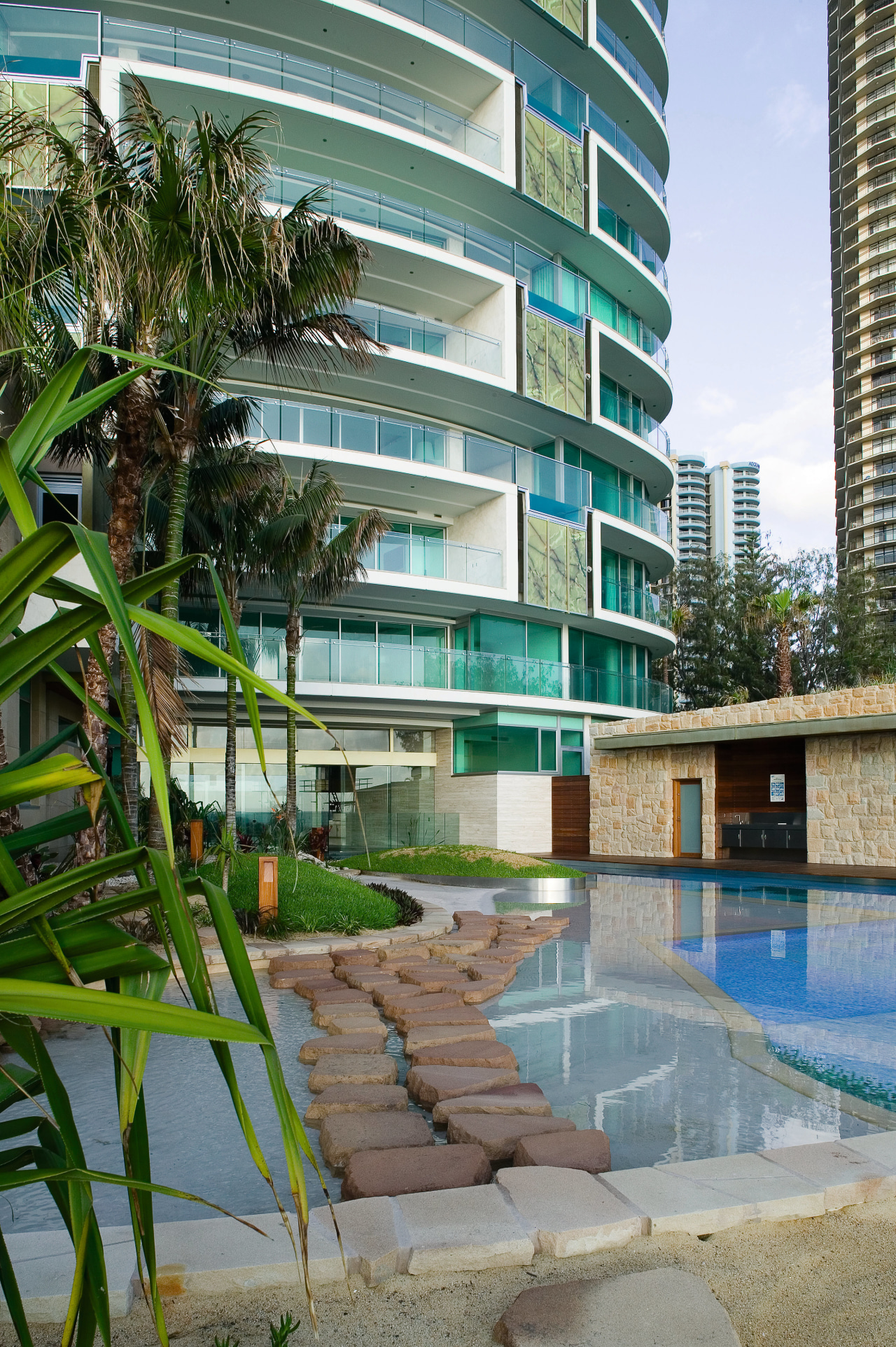 A view of the sandstone stepping stones, sandstone apartment, architecture, arecales, building, condominium, estate, hotel, mixed use, palm tree, property, real estate, reflection, residential area, resort, swimming pool, water, gray