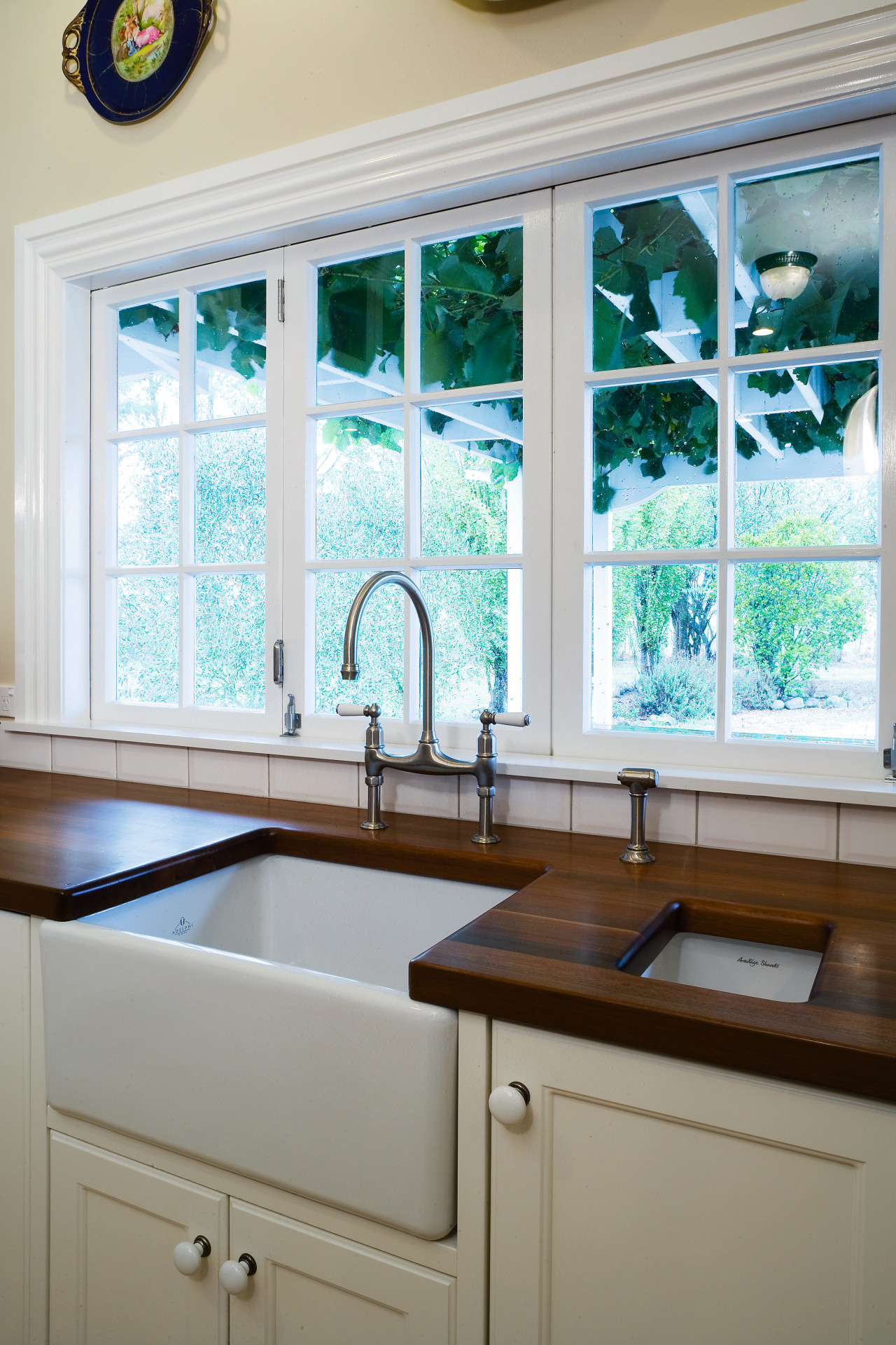 A view of this kitchen featuring tiled flooring, cabinetry, countertop, home, interior design, kitchen, room, sink, window, gray