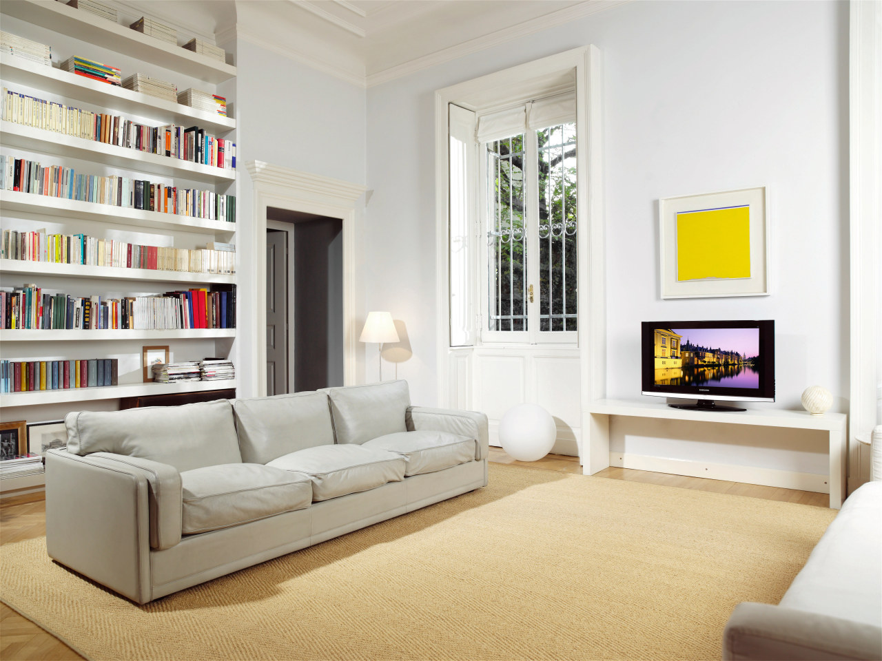 A view of this living area featuring furniture, couch, floor, furniture, home, interior design, living room, room, shelving, wall, white