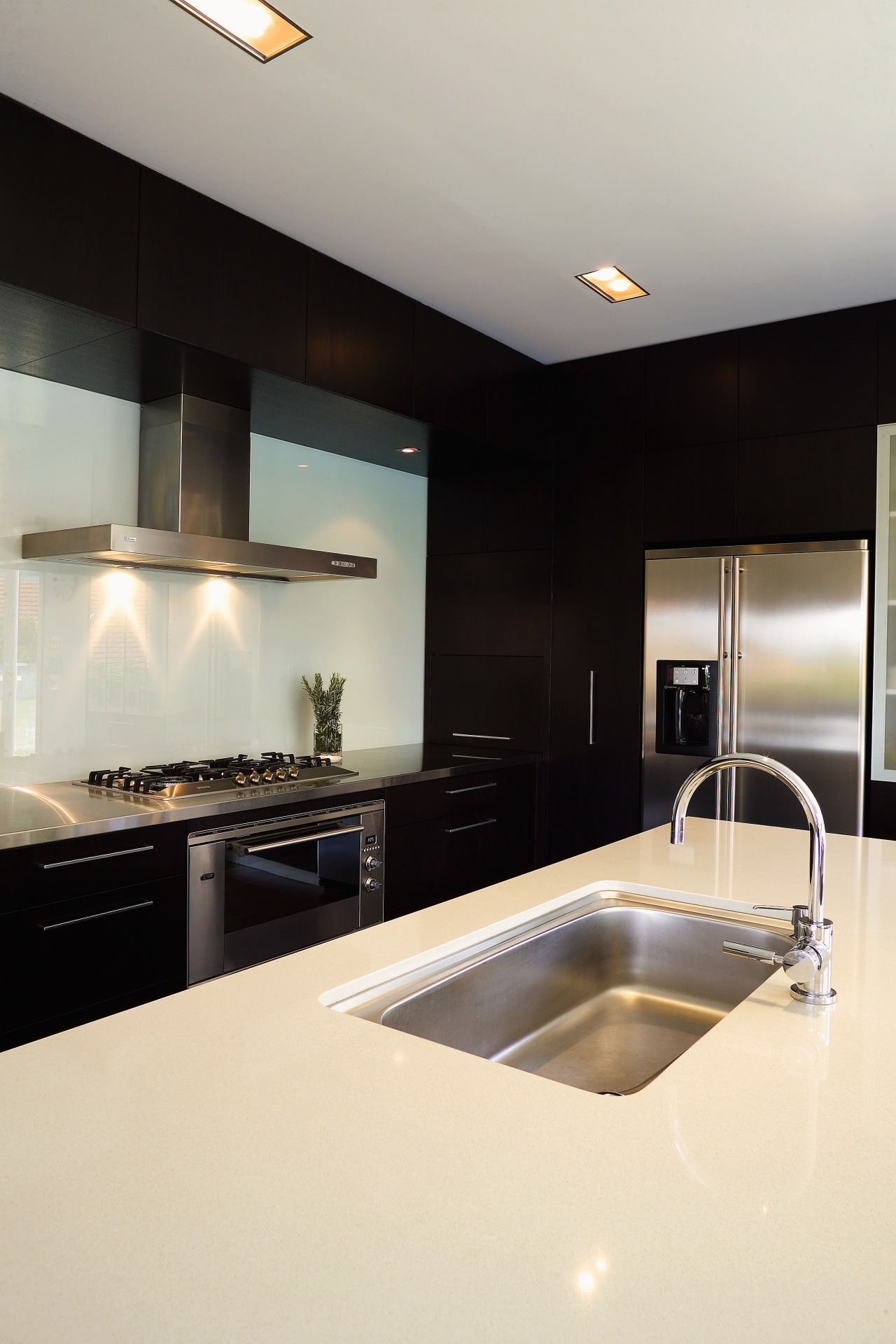 A view of athis kitchen featuring mahogany and countertop, interior design, kitchen, room, sink, white, black