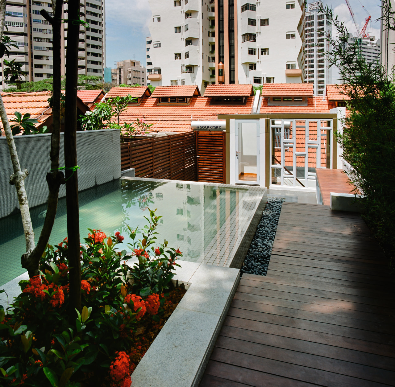 A view of this outdoor entertainment area featuring apartment, architecture, balcony, condominium, deck, house, outdoor structure, plant, real estate, reflection, residential area, walkway, water, black, gray