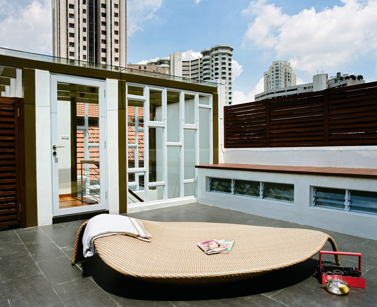 A view of this outdoor entertainment area featuring architecture, condominium, furniture, real estate, roof, gray, white