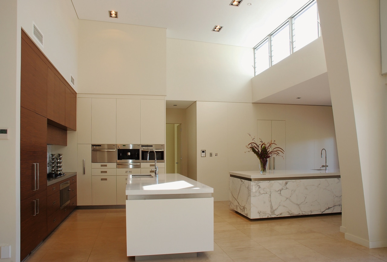 The island in this kitchen have benchtops of architecture, cabinetry, ceiling, countertop, daylighting, floor, home, interior design, kitchen, property, real estate, room, gray, brown