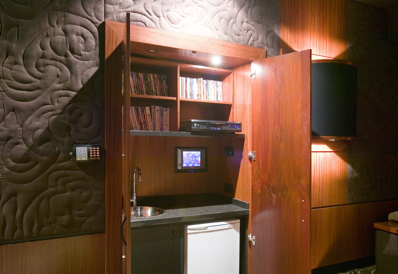 A cabinets hide a wall mounted touchpad fof cabinetry, furniture, interior design, room, wood, brown