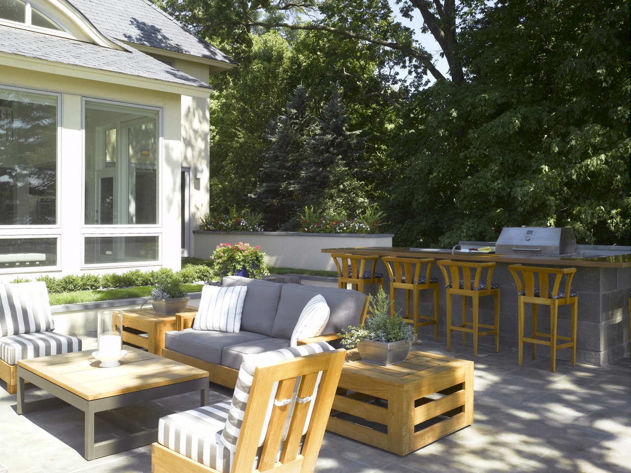 A view of the outdoor courtyar featuring taupe backyard, chair, deck, furniture, outdoor furniture, outdoor structure, patio, table, yard