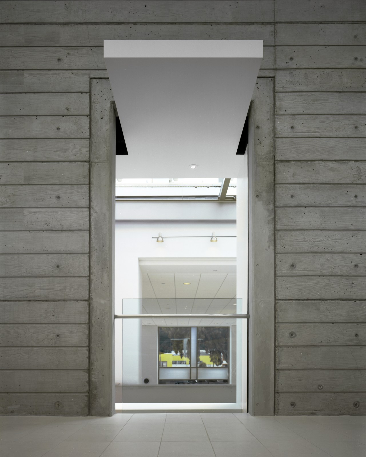 A concrete projection draws attention to an opening architecture, daylighting, door, facade, home, house, window, gray