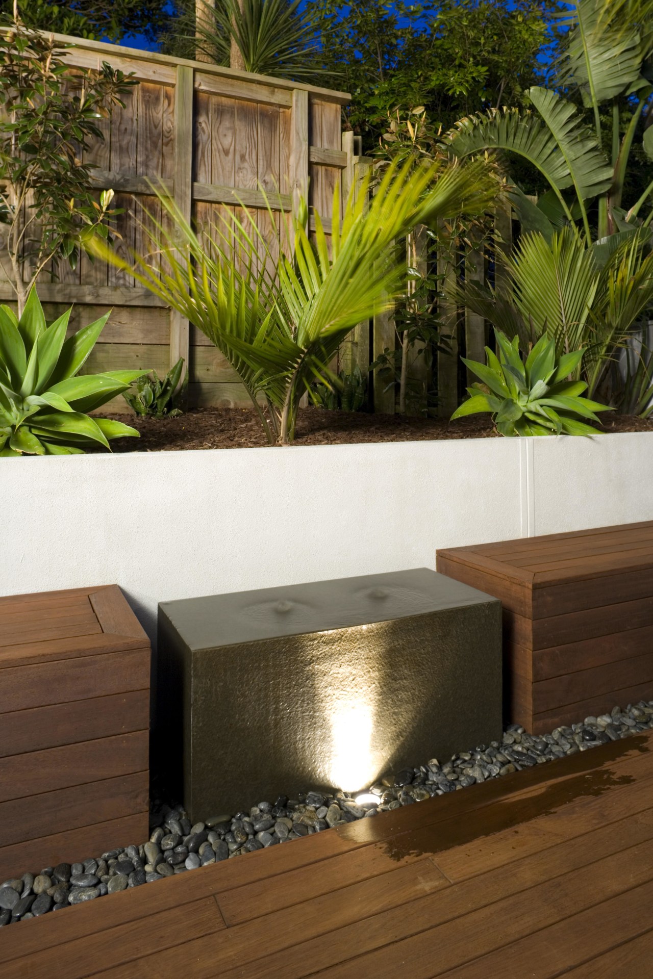 A close up view of the water feature. arecales, backyard, landscaping, outdoor structure, palm tree, plant, wall, brown