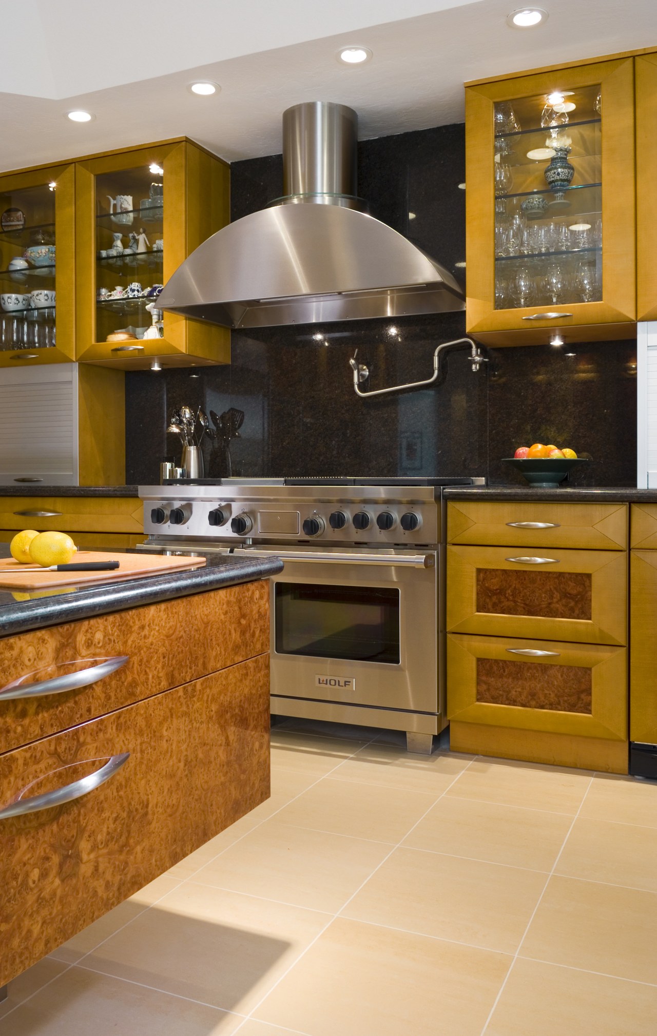 view of kitchen featuring cooking appliances, cooktop, oven, cabinetry, countertop, cuisine classique, floor, flooring, hardwood, interior design, kitchen, kitchen stove, room, under cabinet lighting, wood flooring, brown, orange