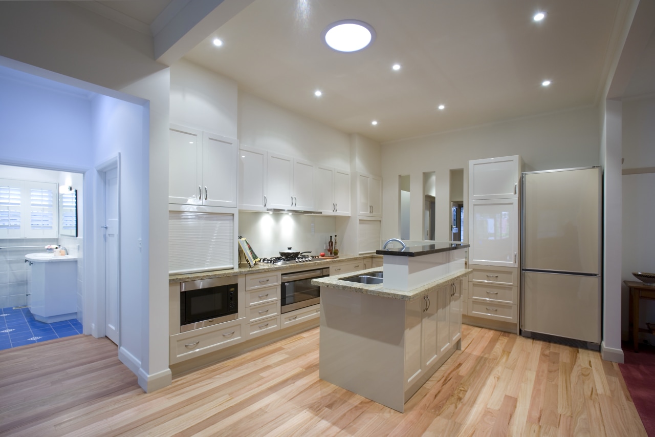 A view of a kitchen designed by a cabinetry, ceiling, countertop, floor, flooring, hardwood, interior design, kitchen, laminate flooring, real estate, room, wood flooring, gray