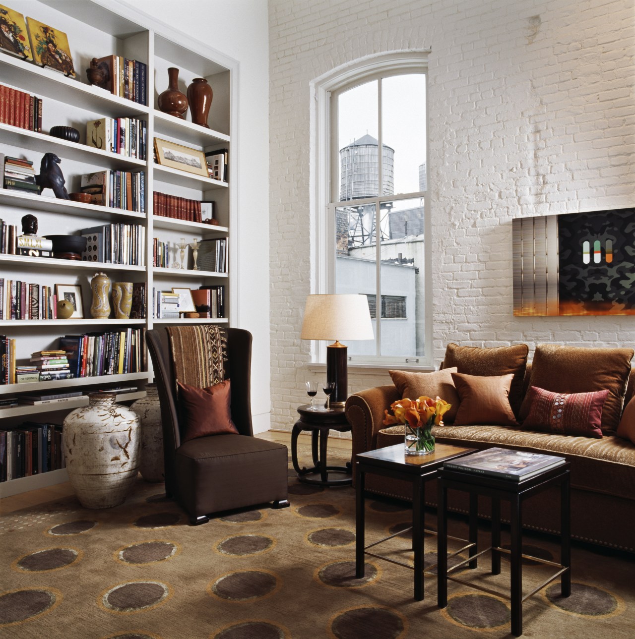 Collected artifacts are a feature of all the bookcase, chair, floor, flooring, furniture, home, interior design, living room, room, shelf, shelving, gray