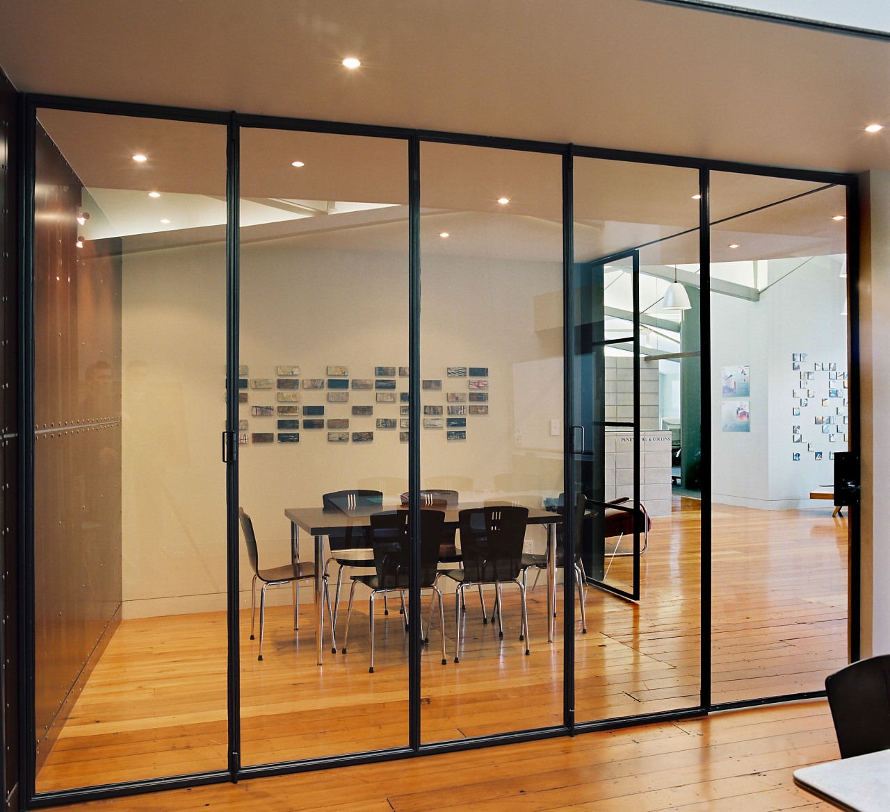 Steel-and-glass sliding doors allow the two meeting rooms architecture, ceiling, door, floor, flooring, furniture, glass, interior design, wall, window, brown, orange