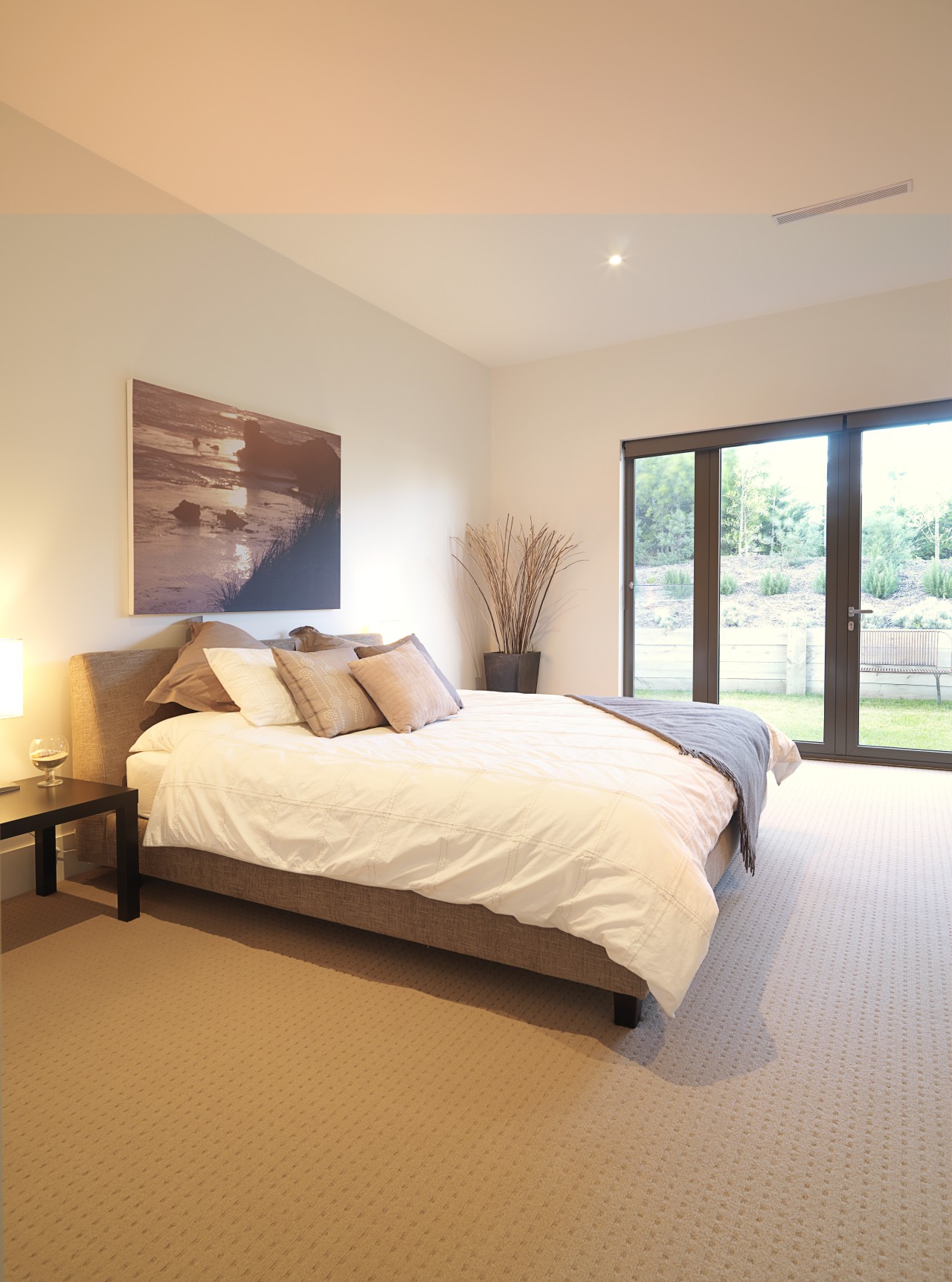 View of the master suite featuring bed with bed, bed frame, bed sheet, bedroom, ceiling, daylighting, estate, floor, flooring, hardwood, home, interior design, mattress, property, real estate, room, wall, window, wood, wood flooring, orange, white