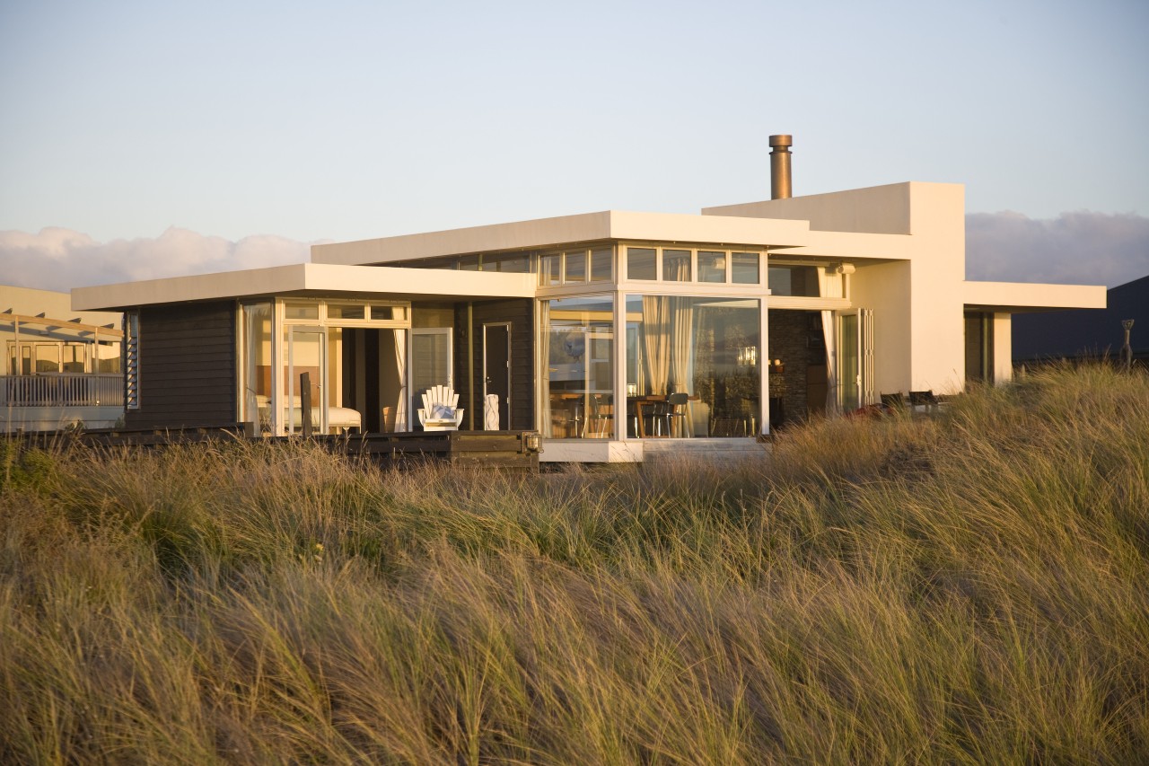 A solid central wall grounds this beach house, architecture, facade, home, house, property, real estate, residential area, sky, brown, white