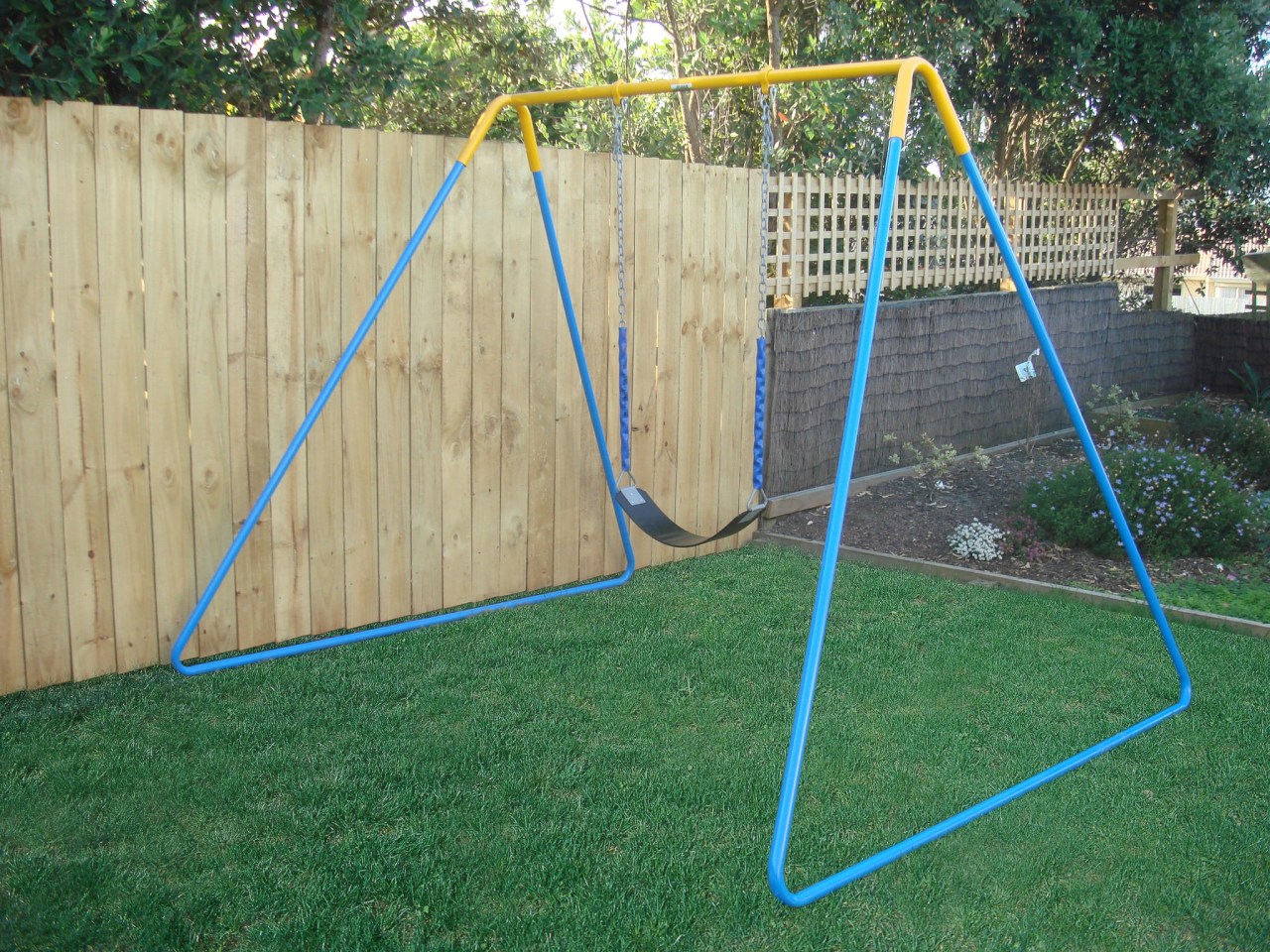 Image of outdoor play equipment created by Adams backyard, fence, grass, net, outdoor play equipment, play, playground, public space, swing, wood, yard, green