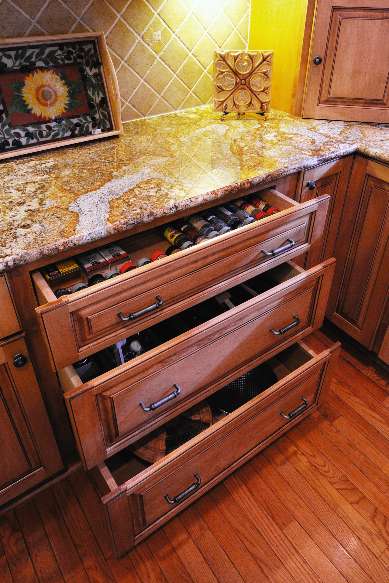 Image of a kitchen and features cabinetry from cabinetry, chest of drawers, countertop, drawer, floor, flooring, furniture, hardwood, room, table, wood, wood flooring, wood stain, red