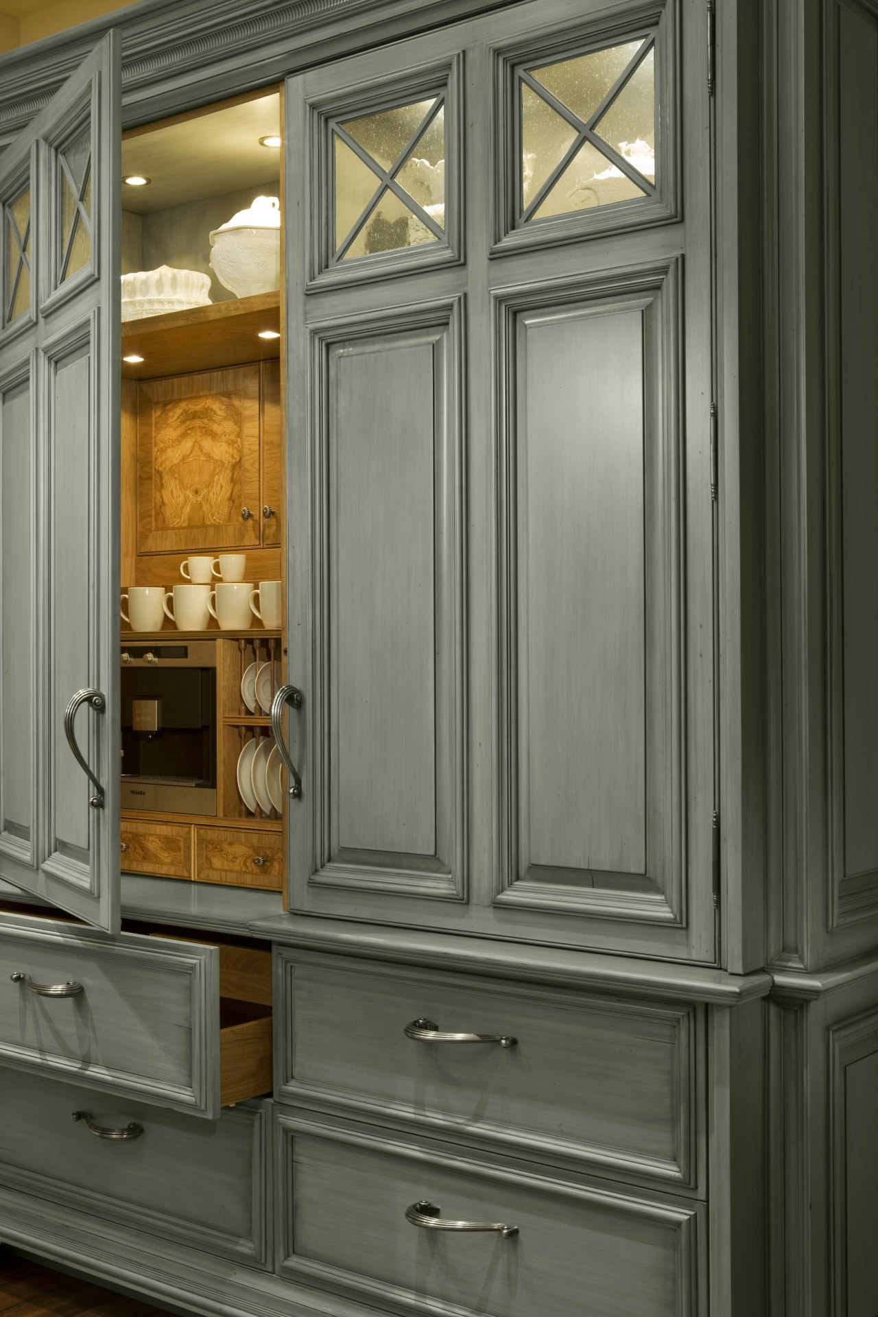 The nuHaus showroom kitchen also has a furniture-style cabinetry, countertop, cupboard, furniture, wood stain, gray, black