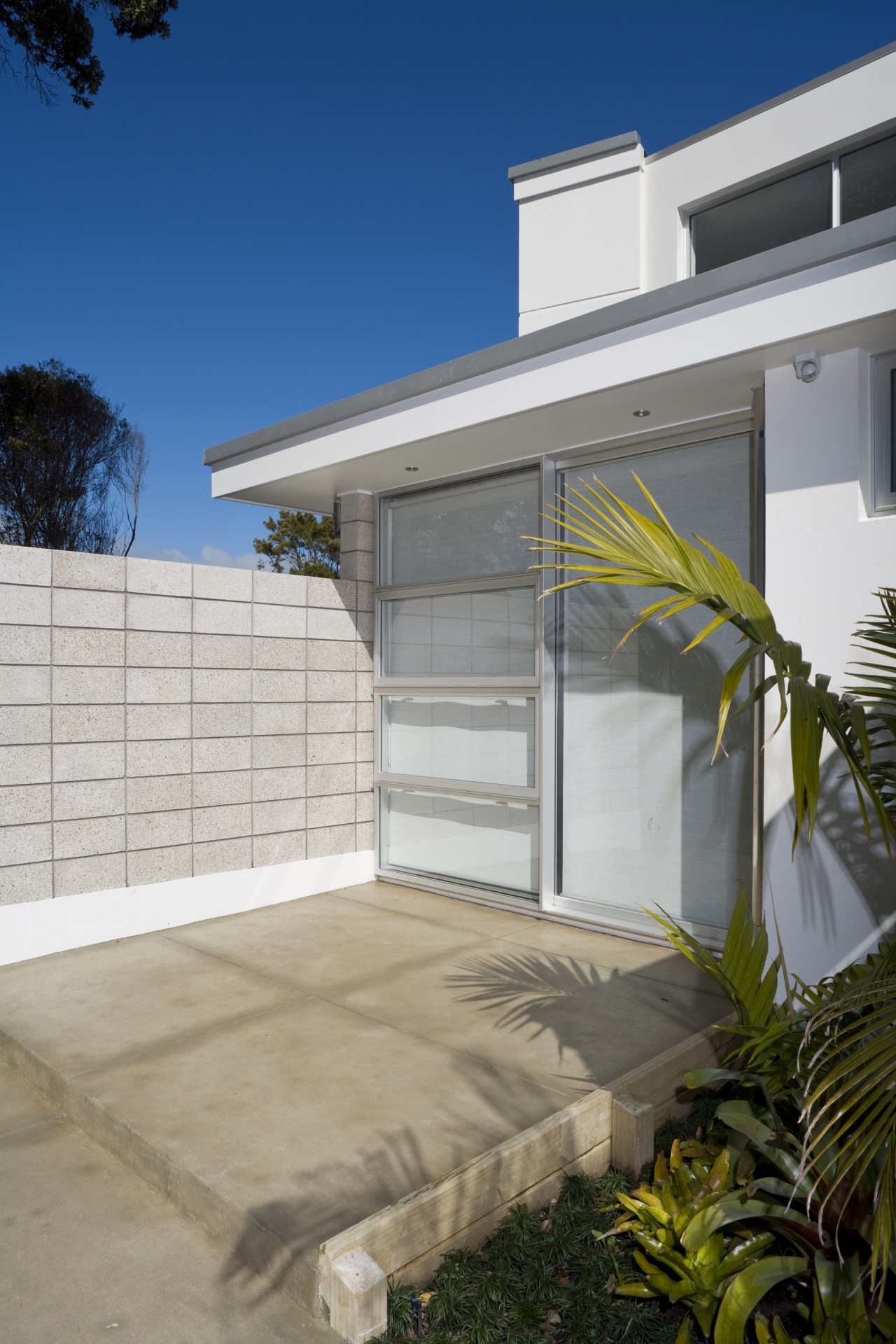A prominent wall blocks the view of passer-by architecture, door, estate, facade, home, house, property, real estate, residential area, siding, window, gray