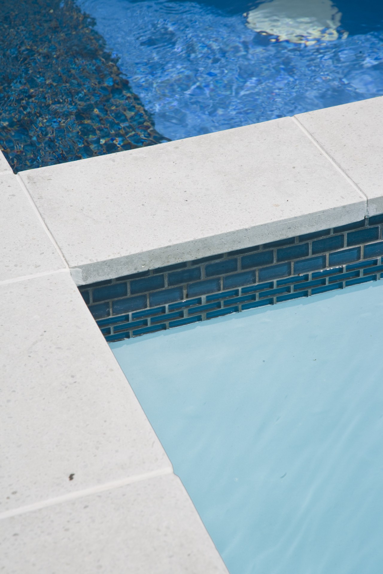 View of the pool tiling and paving. aqua, azure, blue, daytime, floor, line, reflection, sea, sky, swimming pool, turquoise, water, teal, white